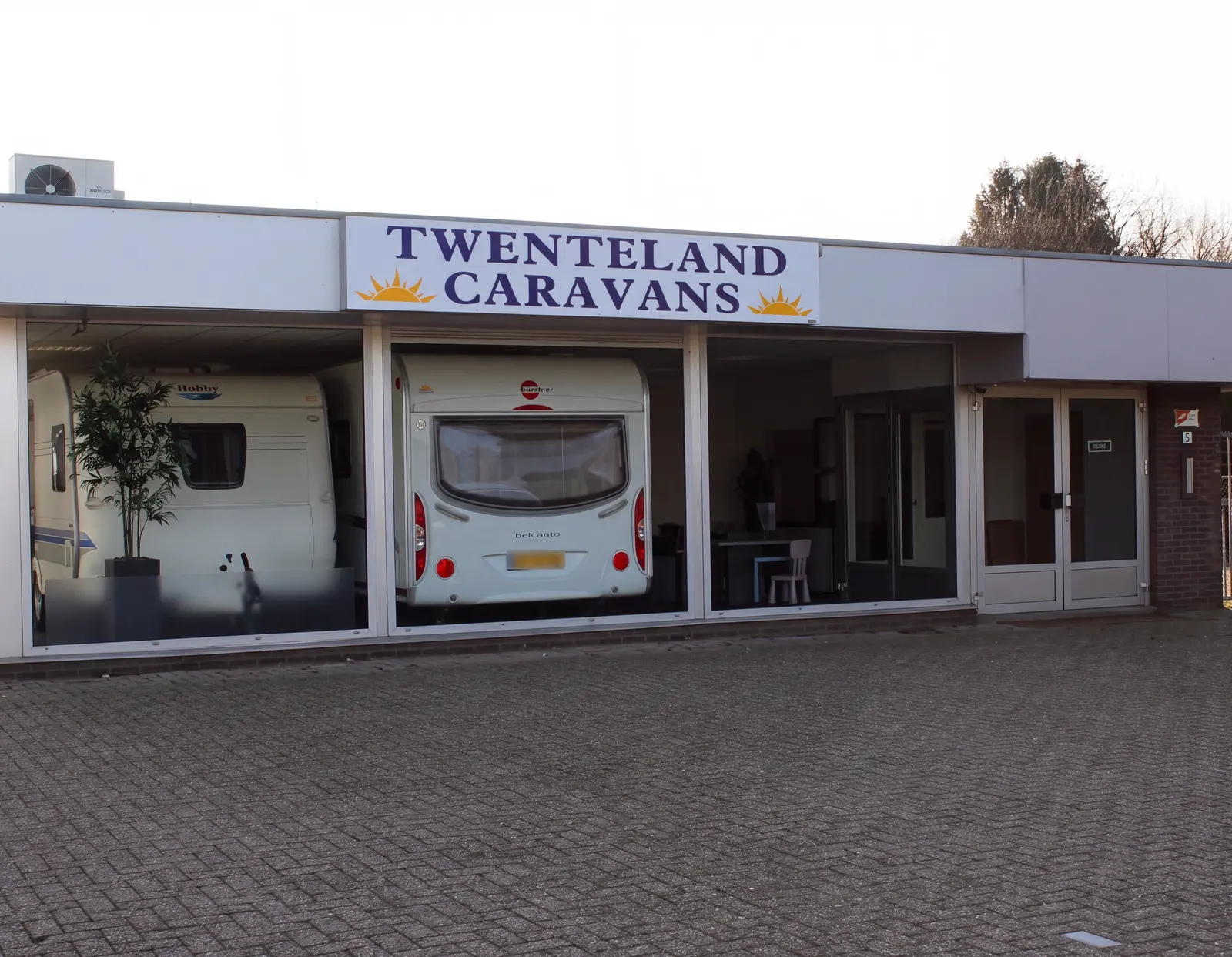 Showroom van Twenteland Caravans aan de Westermaatsweg in Hengelo, met naambord en zonlogo boven de etalageruiten